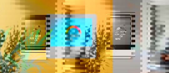 A tablet on a wall displays a healthy "Air Quality Index" with a rainbow meter