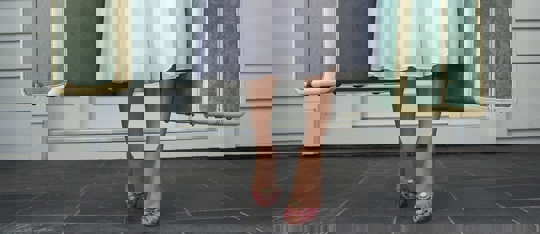 A woman in a white dress stands on a porch